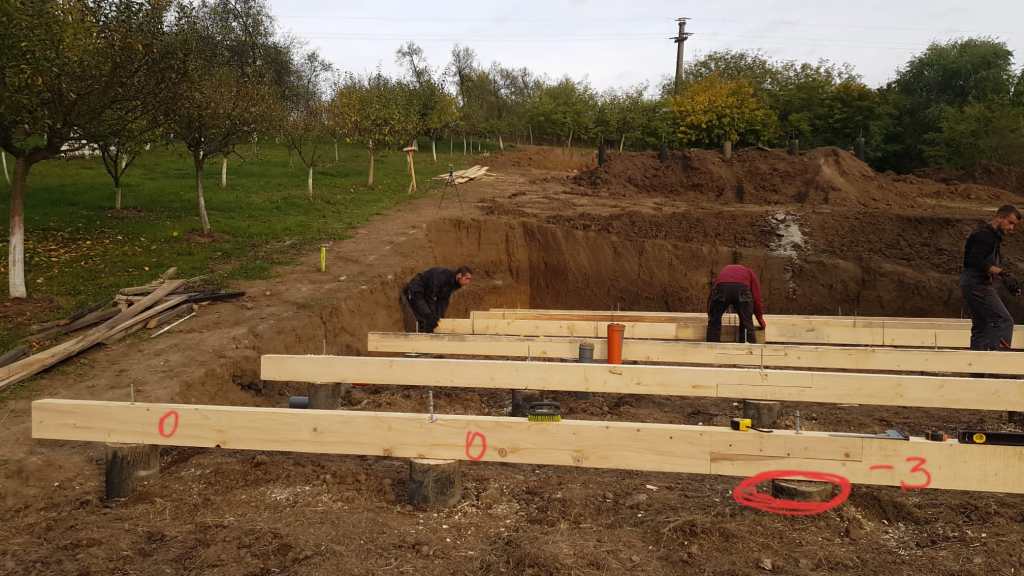 Grinzi de lemn peste piloni de beton armat la o casa tip a frame